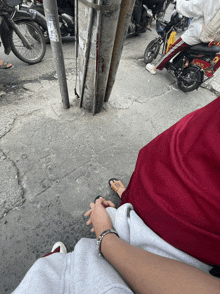 a person in a red shirt is holding another person 's hand on a street
