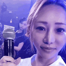 a woman is holding a microphone in her hand