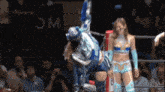 a woman in a wrestling ring with the word wc on the wall behind her