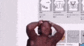 a shirtless man wearing headphones is standing in front of a wall with shirts on it .