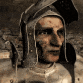 a man in armor with a helmet on his head is looking at the camera .