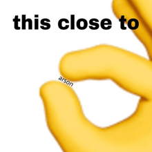 a close up of a yellow hand with the words " this close to arson " written on it