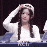 a girl sitting at a table with kei written on the table