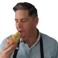 a man wearing a blue shirt and black apron is eating a piece of food