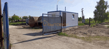 a white building with a blue fence and a sign that says webtoeki