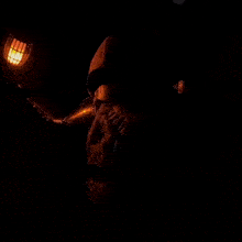 a close up of a lantern with a flame coming out of it in a dark room .