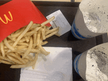 a bag of mcdonald 's french fries next to a cup of ice cream