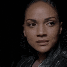 a close up of a woman 's face with a leather jacket on