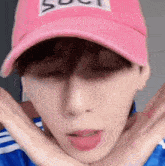 a close up of a person wearing a pink baseball cap .