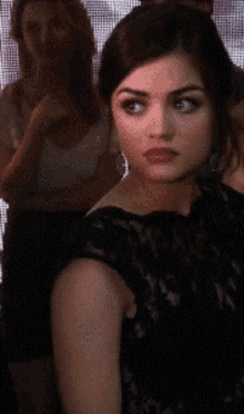 a woman in a black dress with red lipstick looks at the camera