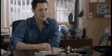 a man sitting at a desk with the words battin ' a thousand here david below him