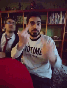 a man wearing a sweater that says no time on it