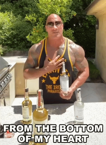 a man in a tank top that says the iron paradise holds a bottle of vodka