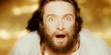 a man with a beard and long hair is making a surprised face