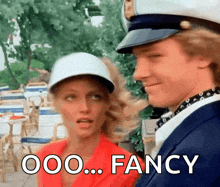 a man and a woman are standing next to each other and the man is wearing a captain 's hat ..