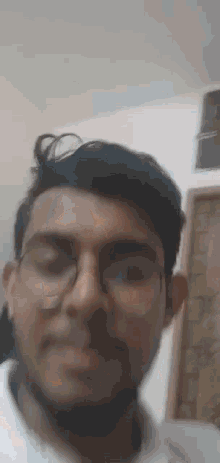 a man wearing glasses is making a funny face .