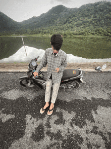 a man standing next to a motorcycle with a sticker on the back that says ' ec '