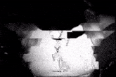 a black and white photo of a person wearing a necklace with the letter a