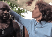 a man in a black tank top and a woman in a blue shirt