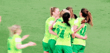 a group of female soccer players are hugging each other and one has the number 14 on her shirt