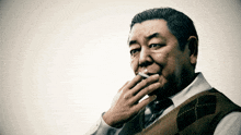a man smoking a cigarette with his hand on his mouth