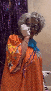 a woman with glasses and a cane is talking on a cell phone