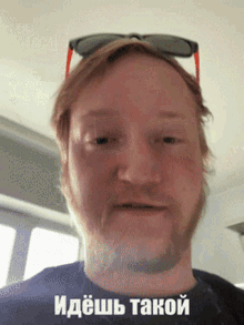 a man with a beard wearing sunglasses and a black shirt has a caption in a foreign language
