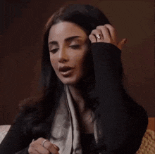 a woman is covering her mouth with her hand and looking surprised .