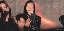 a group of women are dancing on a stage and one of them is clapping her hands .