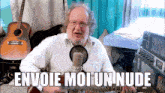 a man singing into a microphone with the words envoie moi un nude written below him