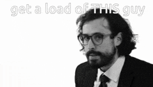 a man in a suit and tie with the words get a load of this guy behind him