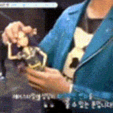 a person in a blue jacket is holding a toy in their hands