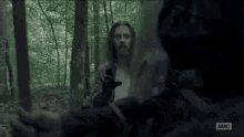 a man in armor is holding a sword in his hand in a dark room .
