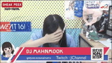 a woman covering her face in front of a sign that says twitch