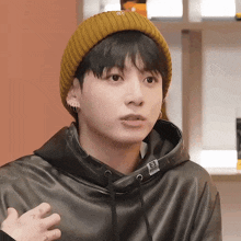 a close up of a person wearing a yellow beanie and a black hoodie with the number 3 on it