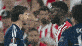 two soccer players are standing next to each other on the field .