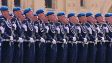 a group of soldiers in blue uniforms stand in a row