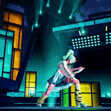 a girl is playing a guitar on a stage with lights behind her