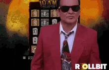 a man in a red suit and tie is standing in front of a screen that says swan dead or