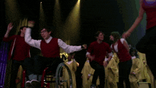 a man in a wheelchair is dancing on stage with other people