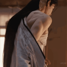a woman with long hair is taking off a white shirt with the letters jxjb on the bottom
