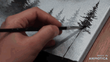 a person is painting trees on a canvas with the words made in animotica on the bottom