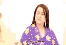 a woman in a purple shirt is making a funny face and saying oh my maata .