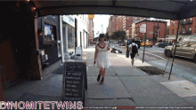 a woman in a white dress walks down a sidewalk in front of a sign that says tonight 's menu