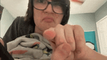 a woman wearing glasses is pointing at something