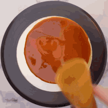 a spoon is being used to spread caramel on a cake