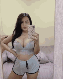 a woman taking a picture of herself in a mirror with her phone