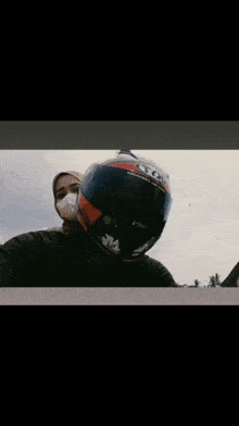 a man wearing a helmet is kissing a woman wearing a face mask ..