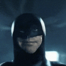 a close up of a man wearing a batman costume