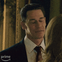 a man in a suit and tie is looking at a woman .